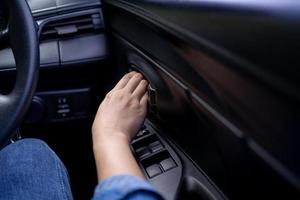 Woman's hand pushing a button to open a car door photo