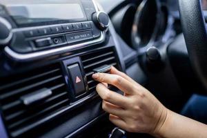 Close-up of the hand adjusting the air conditioning button in the car. photo