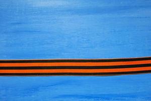 May 9 russian holiday, victory day, banner or poster. St. George striped ribbon on blue background. photo