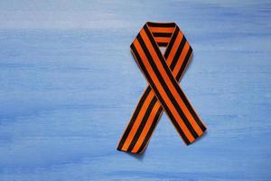 May 9 russian holiday, victory day, banner or poster. St. George striped ribbon on blue background. photo