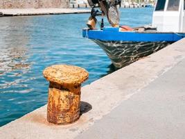 Big rusty mooring peg on a concrete pier in a port bay photo