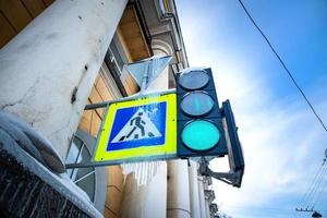 Crosswalk sign and traffic light covered with icicles photographed from below photo