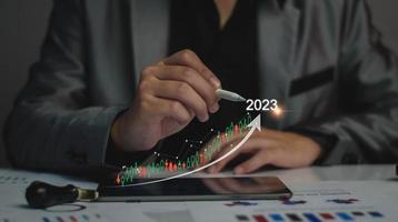 objetivos de marketing digital 2023. hombre de negocios que analiza el marketing de Internet en línea, la planificación empresarial de 2023, el aumento de los negocios, el análisis del mercado de valores en línea, el gráfico de acciones el próximo año, el comercio de acciones digitales foto