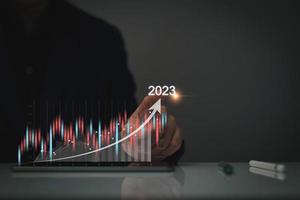 objetivos de marketing digital 2023. hombre de negocios que analiza el marketing de Internet en línea, la planificación empresarial de 2023, el aumento de los negocios, el análisis del mercado de valores en línea, el gráfico de acciones el próximo año, el comercio de acciones digitales foto