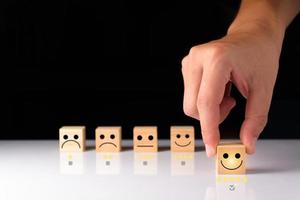 Customer service and Satisfaction feedback concept ,Business people show feedback with smile face wood cube happy Smiley face icon satisfaction in service. wood cubes rating. wood cubes ideas. photo