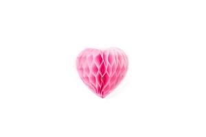 un exuberante corazón de papel rosa sobre un fondo blanco. foto