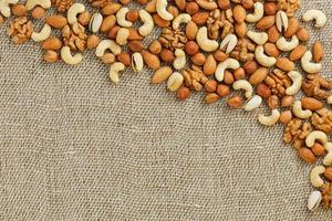 Mix of nuts lying on a background of brown cloth burlap. photo