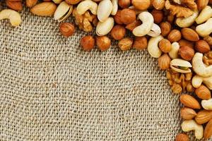 Mix of nuts lying on a background of brown cloth burlap. photo