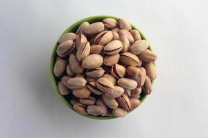 pistachio in shell nuts in a bowl on white background. photo