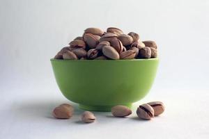 pistachio in shell nuts in a bowl on white background. photo