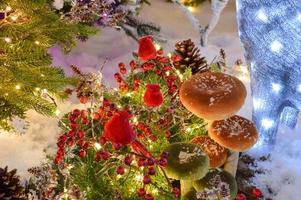 Christmas decor for a shopping center. the trees are decorated with beautiful, shiny, colorful balls. bright birds sit on the branches, mushrooms under the trees photo