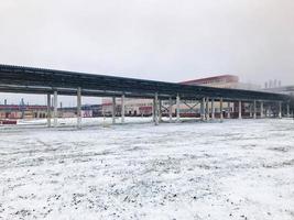 Large iron metal chemical stainless pipe rack with pipes, power equipment at the refinery, petrochemical plant in the winter on the snow