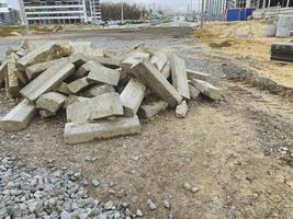 construction site. concrete blocks lie in a pile for the erection of houses and buildings. around stones for the construction of roads and communications photo