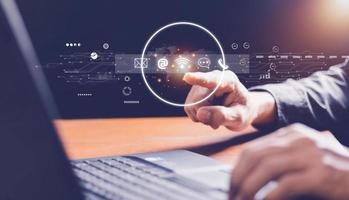 Contact us or Customer support hotline people connect. Businessman using a laptop and touching on virtual screen contact icons , email, address, live chat, internet wifi . photo