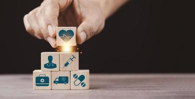 Health medical Insurance Concept, Hand arranging wood cube with medical symbol on pastel blue background, copy space. photo