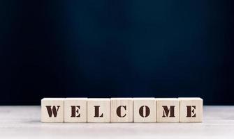 the word WELCOME is written on a wooden cubes structure. Cube on a bright background. Can be used for business, MEDICINE, financial concept. Selective focus. photo