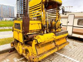 construction equipment on site. construction of houses in a new microdistrict from blocks and glass. yellow construction equipment stands nearby photo