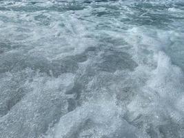 hermoso mar con olas salpicando cálidas y brillantes aguas azules en un cálido resort tropical oriental del sur. fondo, textura foto