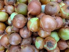 Onions are found in fruit and vegetable market stalls onions on the table neatly photo