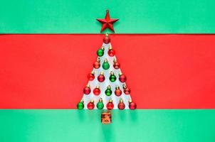 adorno de adornos navideños decorado como árbol de navidad sobre fondo rojo y verde. concepto mínimo de vacaciones. foto
