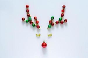 Christmas baubles ornament decorated as reindeer face on white background. Minimal holiday concept. photo