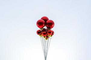 Christmas red baubles ornament set as ballon on top with white background. Minimal holiday concept. photo