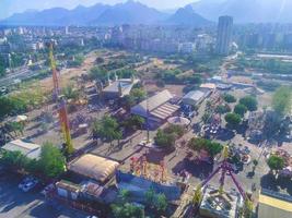 en la ciudad vista a las montañas y al mar. visita turística. casas, edificios, árboles tropicales, palmeras, rotondas, arbustos y caminos son visibles foto