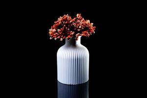 white vase with orange flowers in ice with reflection, black background isolated, photo