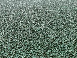 texture, background. coating for a sports field made of rubberized material in green, emerald color. anti-slip running surface photo