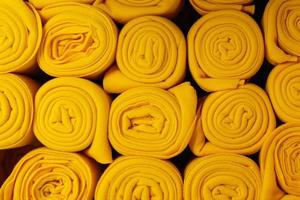 Twisted yellow blankets in a roll as background, home photo