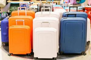 Blue and yellow and white suitcases or travel bag in a row on a shelf photo