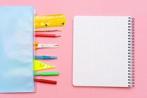 cuaderno escolar y diversos útiles de oficina. concepto de regreso a la escuela foto