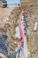 Large red plastic corrugated pipes with wires for a transformer substation at a construction site during a repair in a new underground community photo