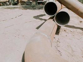 metal pipe lies on the ground. the metal pipe is soldered from the material. laying communications for residential buildings photo