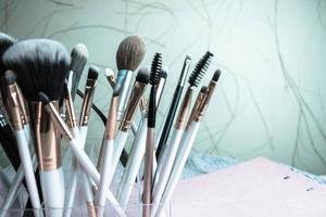 A set of beautiful different soft brushes for make-up from natural nap for the guidance of beauty and the application of a tonal foundation in a stand photo