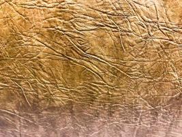 Beautiful abstract texture of yellow brown artificial eco leather with embossed pattern. The background photo