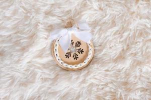 Christmas wooden decoration with ribbon on fluffy light background with copy photo