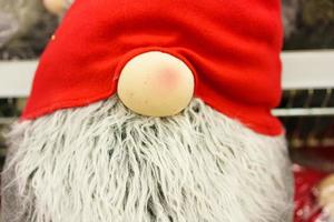 Little santa claus toy, close up. Traditional doll for christmas under the tree. photo