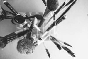 A set of beautiful black and white different soft brushes for make-up from natural nap for beauty guidance and applying a tonal base in the stand photo