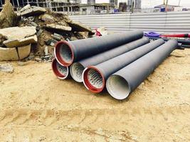 construction site. polypropylene pipes lie on fine sand. nearby concrete blocks for the construction of houses, roads photo