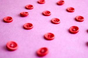 Beautiful texture with many round pink buttons for sewing, needlework. Copy space. Flat lay. Pink, purple background photo