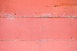 Red iron old scratched ragged metal sheet wall with horizontal stripes. Texture, background photo