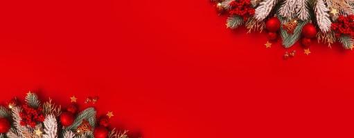 Banner with Christmas decoration and pine tree on red background with copy space. New Year greeting card. Flat lay photo