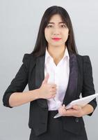 Asain women in suit standing using her digital tablet computer photo