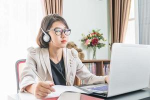 Teenage girl working on laptop in home office photo