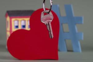 símbolo de la casa con llave de metal y miniatura de propiedad, que simboliza la propiedad de la vivienda foto