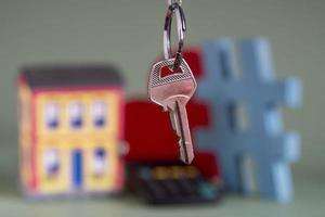 House symbol with metal key and property miniature, symbolizing home ownership photo