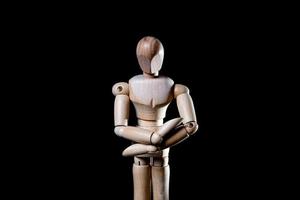 Image of wooden manikin on black background poses different posing photo