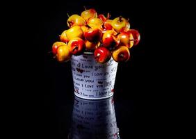 aluminum ice bucket laid in wait for use. stainless multi-colored bucket with red apples photo