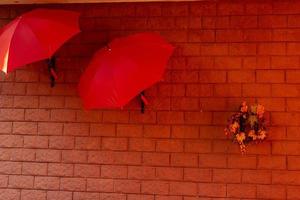 Bright and colorful umbrellas decorate a restaurant. The house covered with wild grapes photo